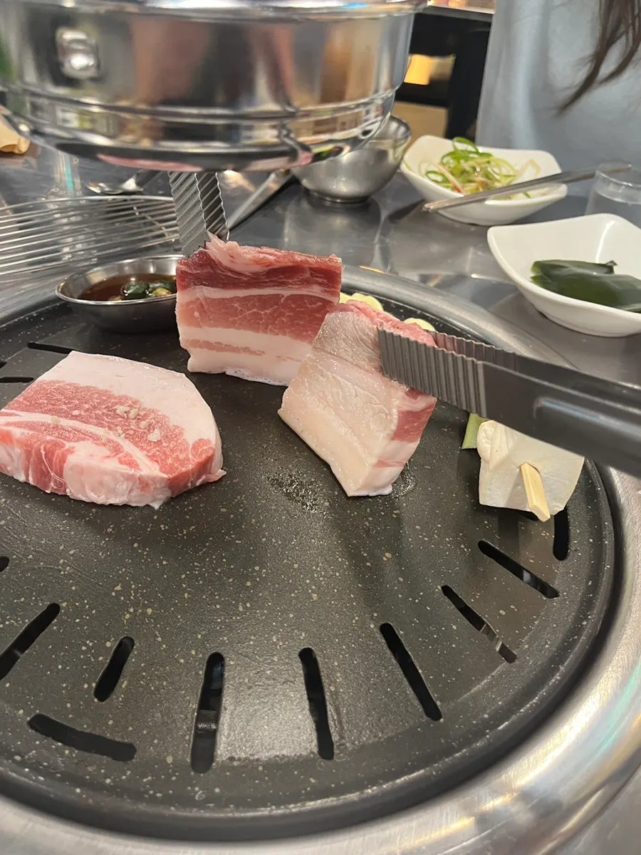 Black pork belly placed on the charcoal grill