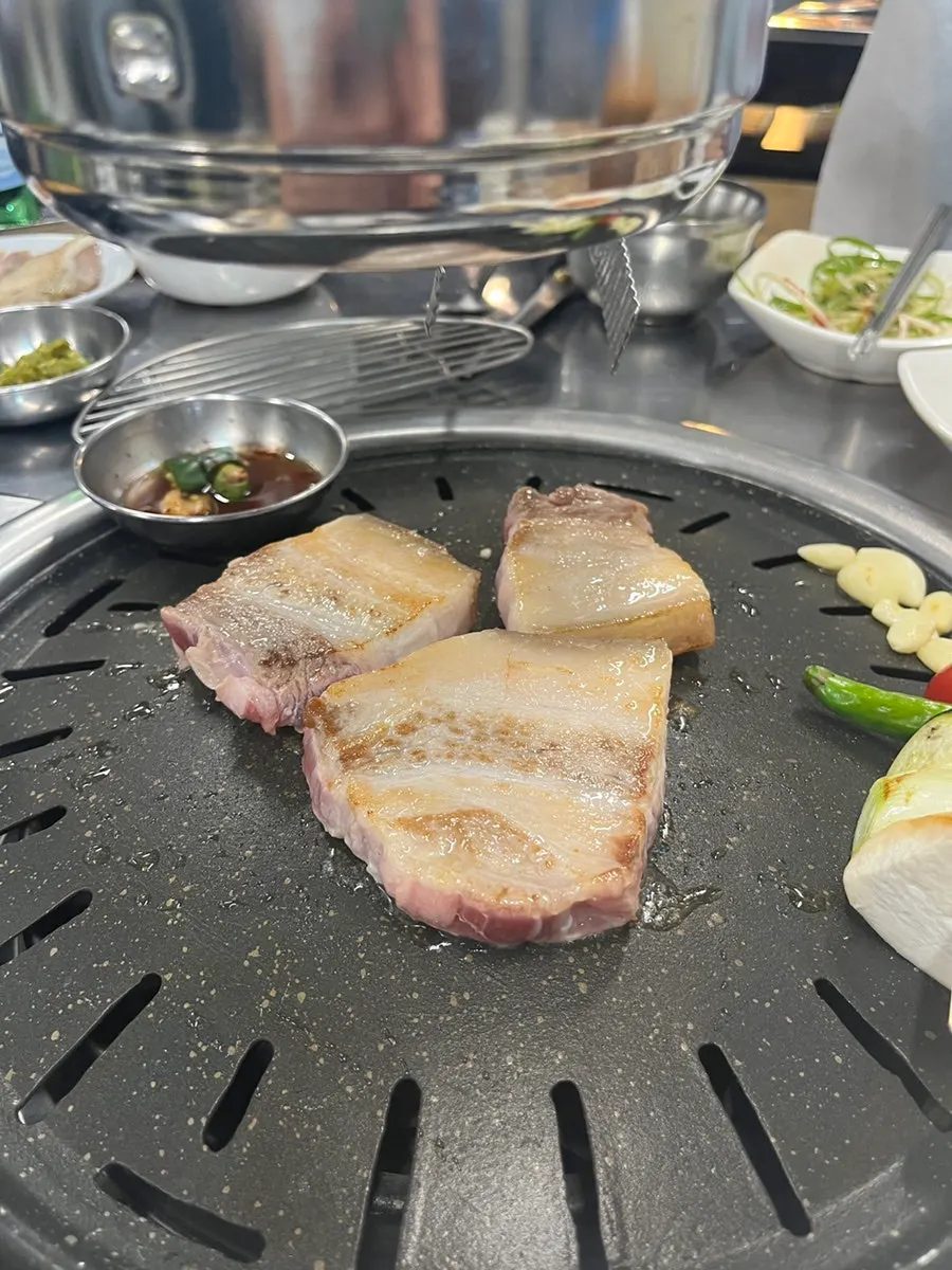 Close-up of pork belly grilling on the pan