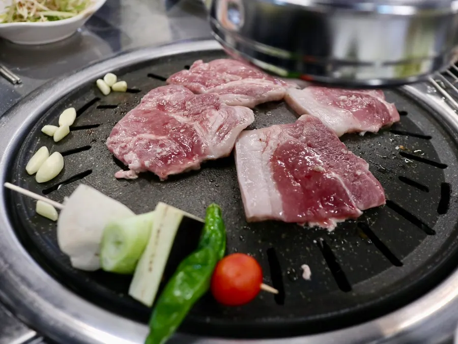放在炭火上的黑猪梅花肉和前腿肉