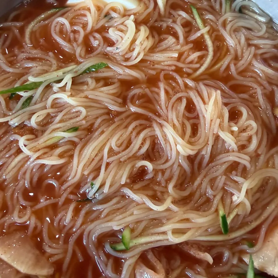 Chewy milmyeon noodles lifted with chopsticks