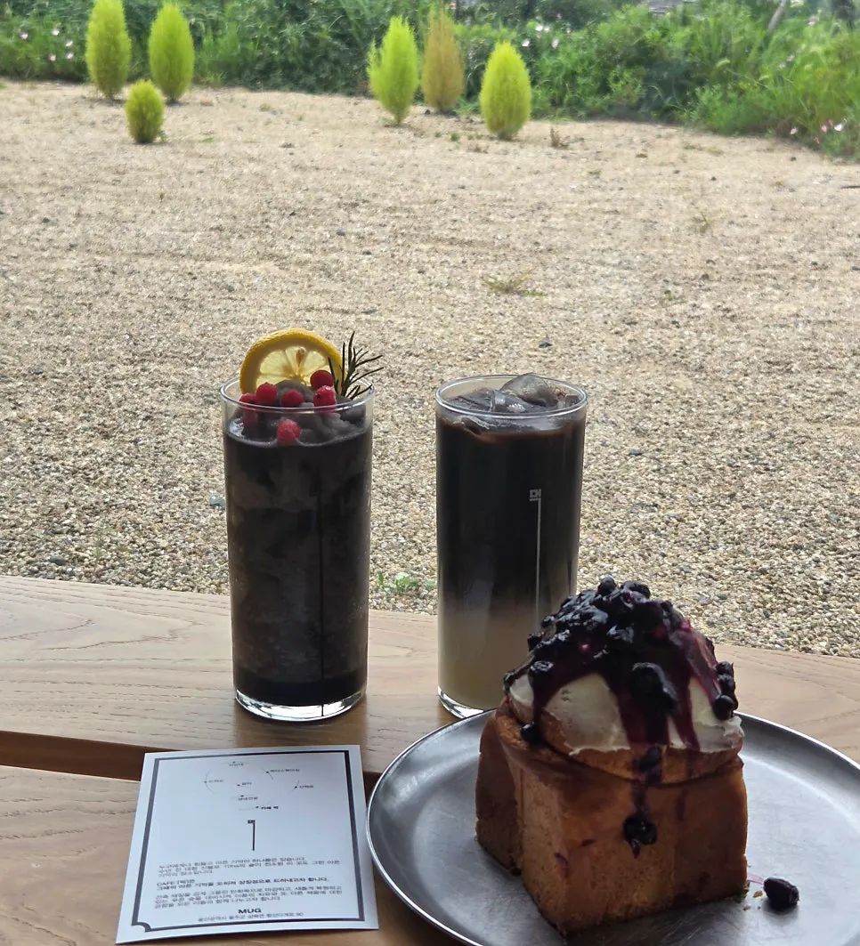 Table setting with MUG black latte, lemon smoothie, and cinnamon roll