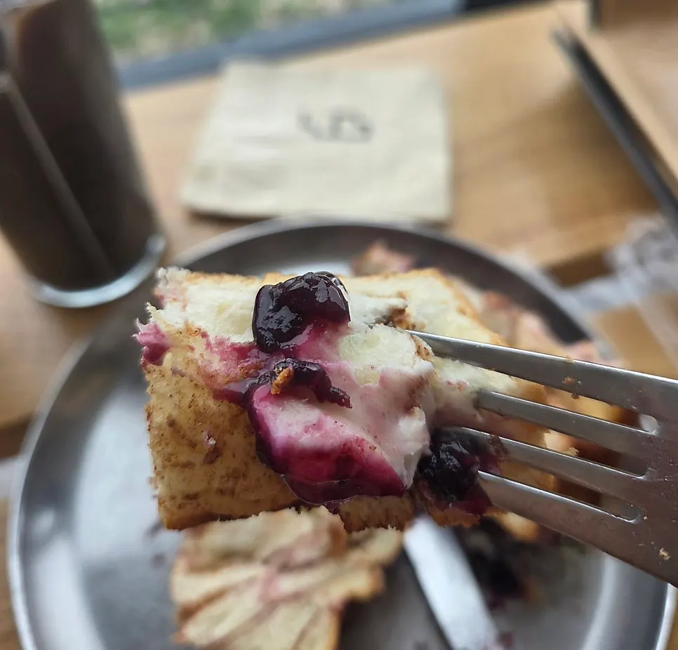 Blueberry cream cheese cinnamon roll enjoyed with a drink