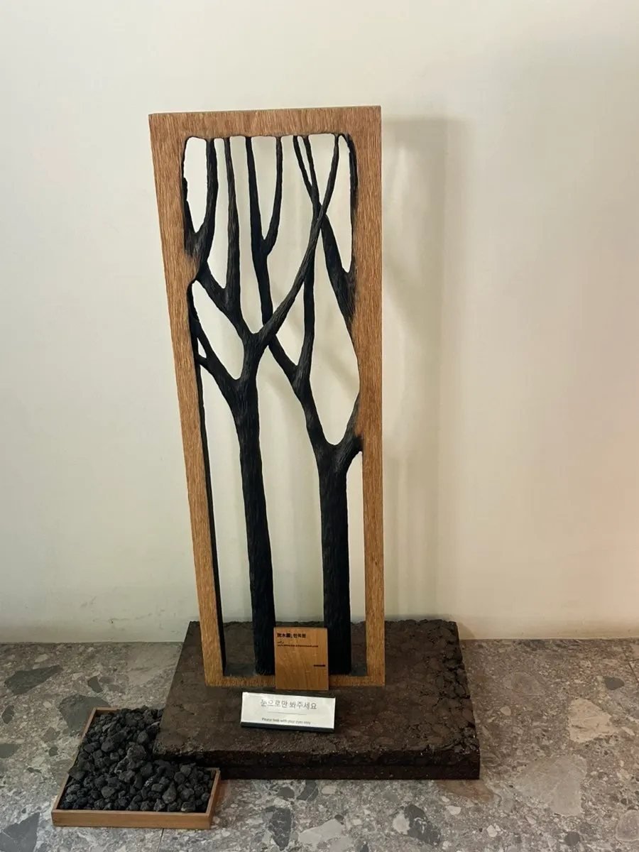 MUG installation decorated with wood and stone burned in a wildfire
