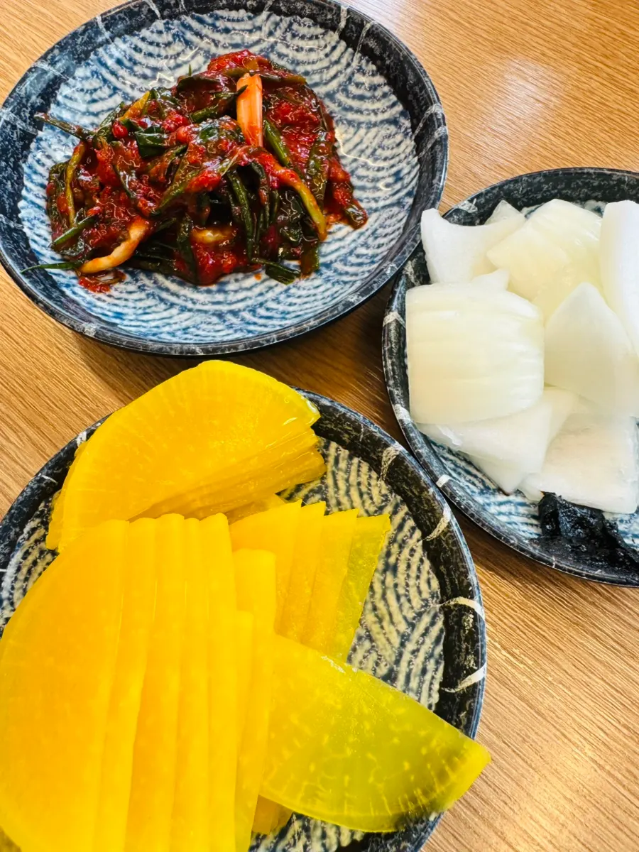 House-made green onion kimchi and pickled radish at the self-serve corner