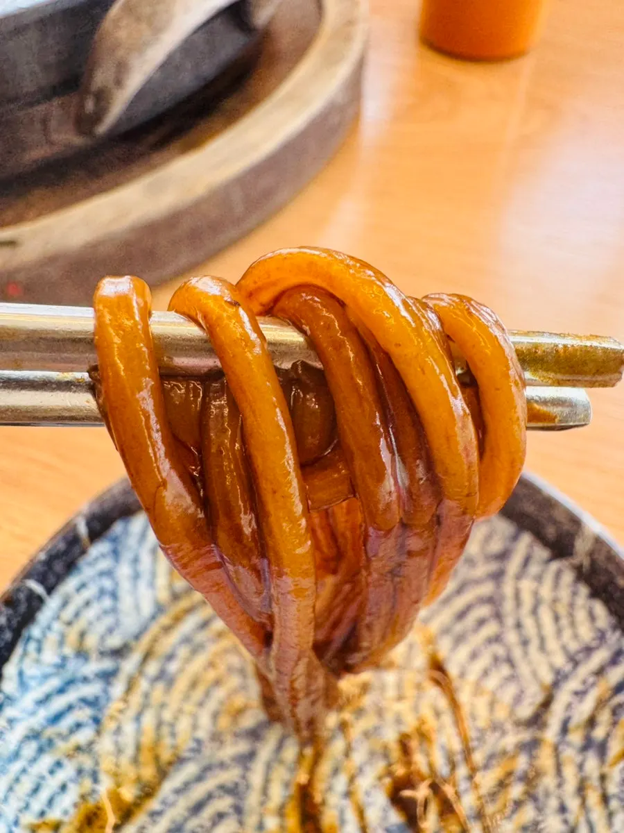 Close-up of stone-plate jajangmyeon topped with seafood