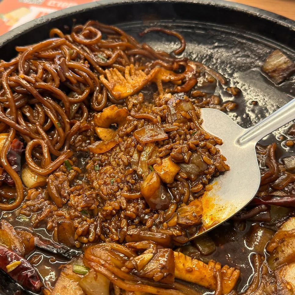 Scooping up the scorched rice layered under the noodles