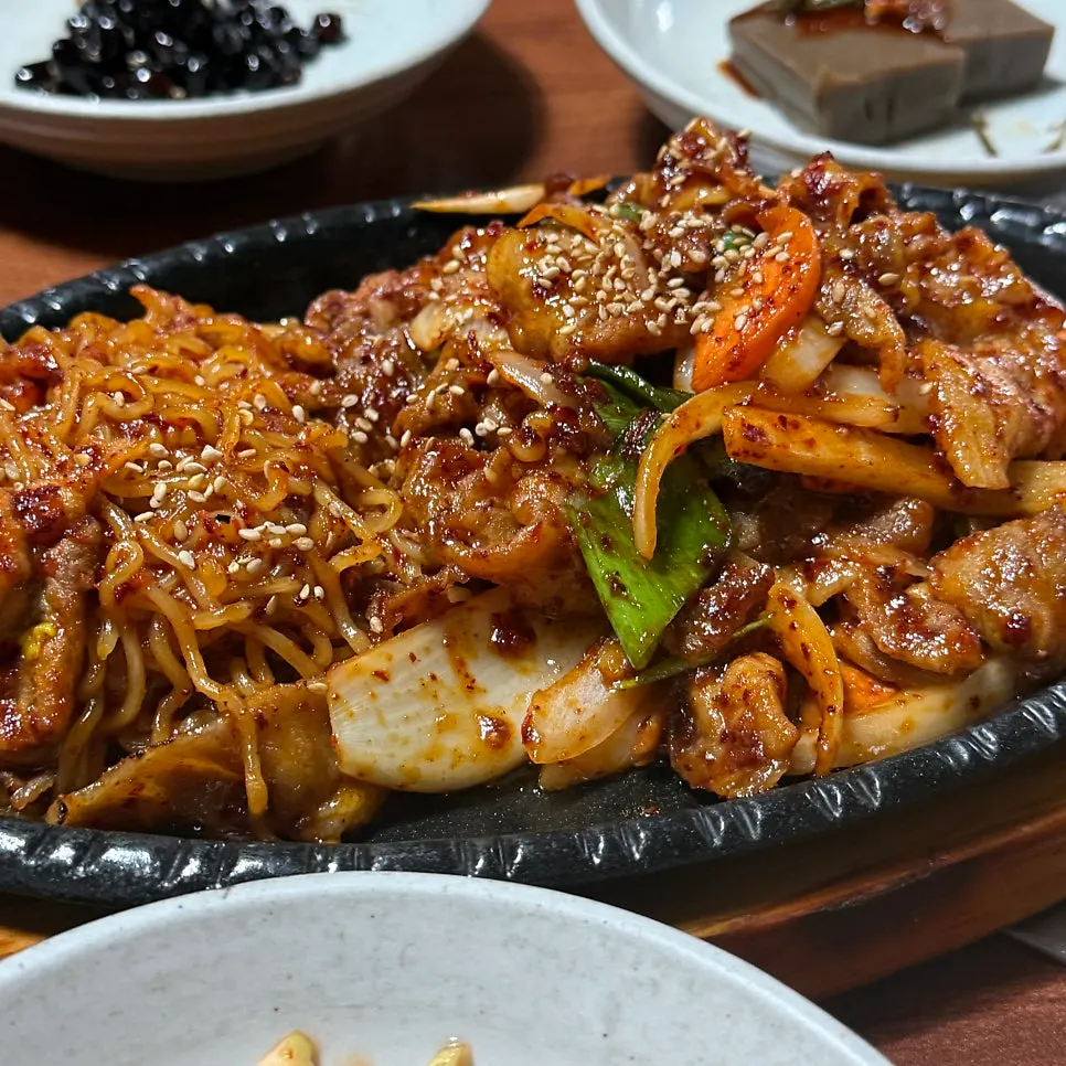 양념이 묻은 제육과 라면사리 가까이