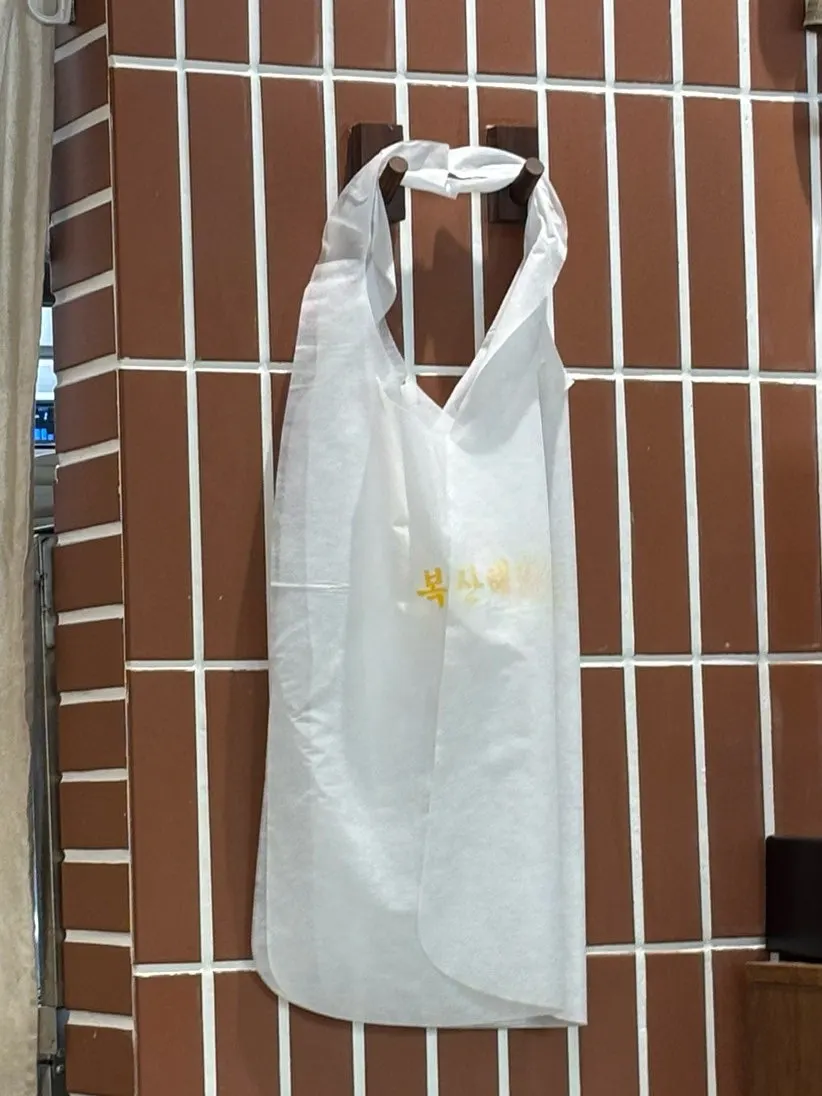 복산해장 내부 좌석과 앞치마 비치 공간