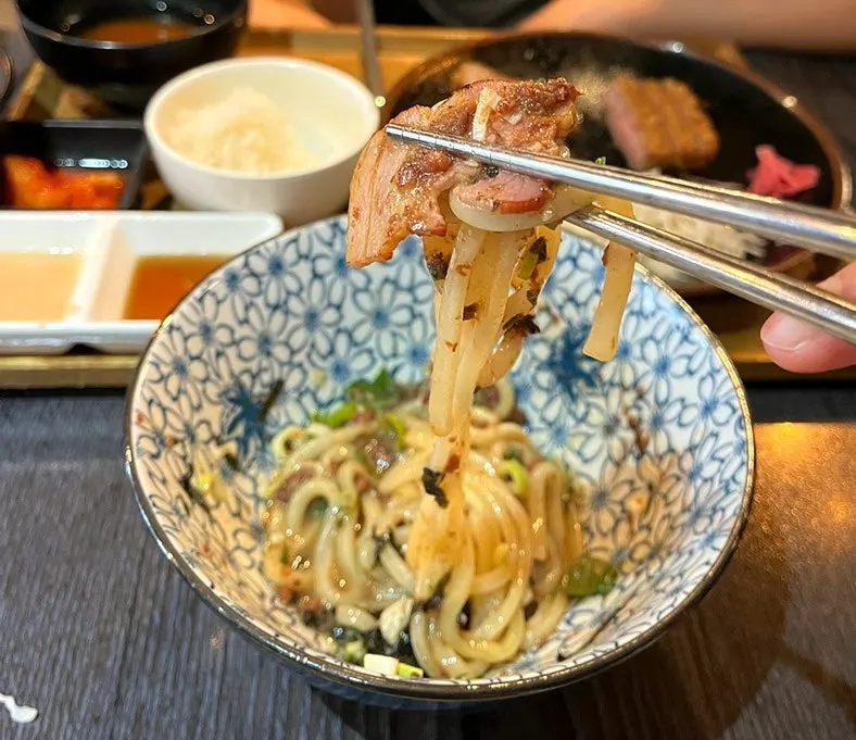 삼겹살과 면을 함께 집어 올린 마제소바