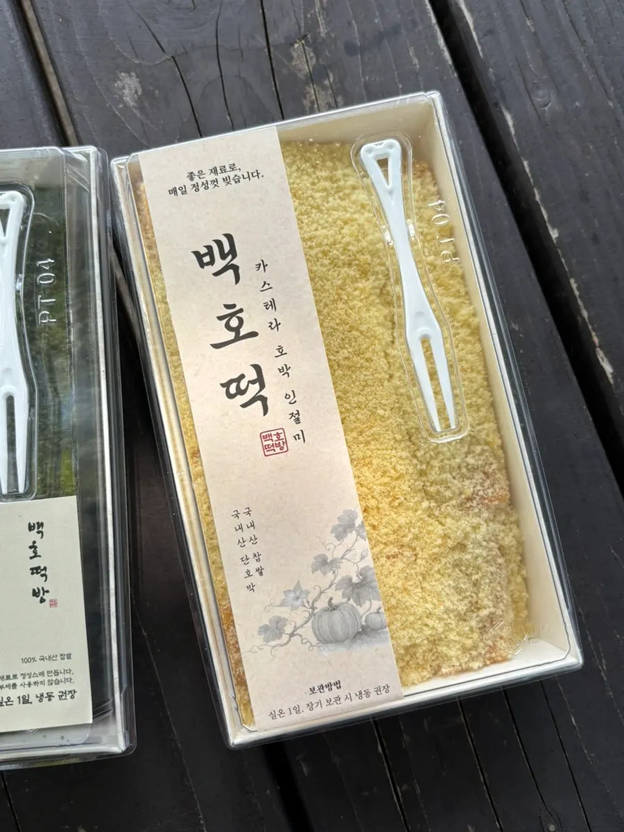 ヨモギのまぶし粉がのったヨモギカボチャ餅の一切れ
