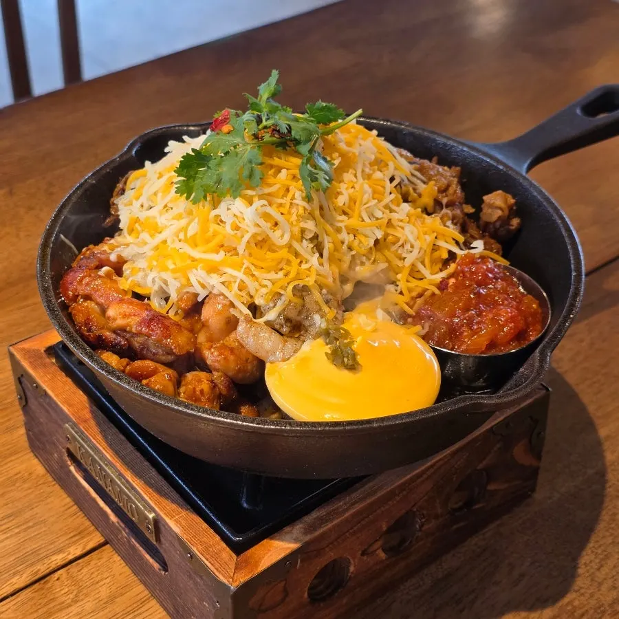 Fajita with meat and cheese on a sizzling hot plate