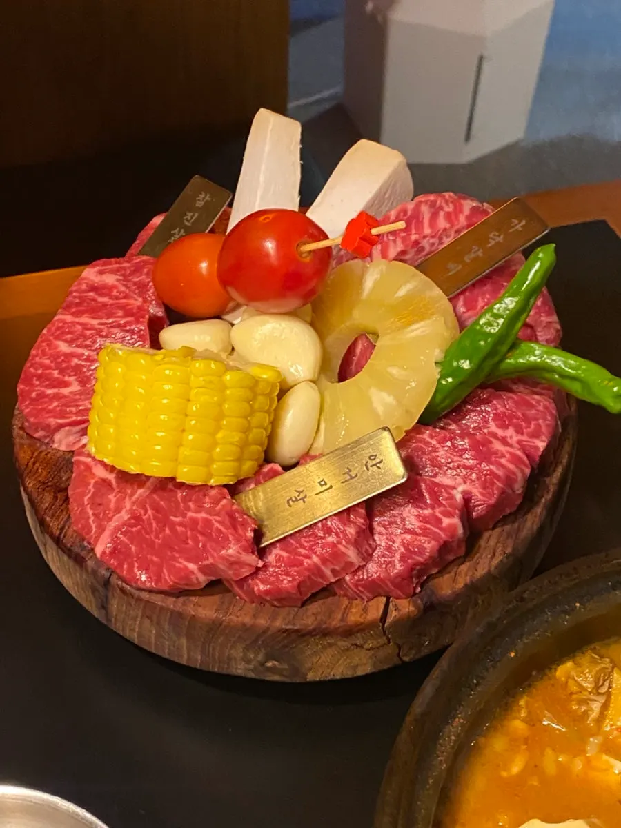 The 85,000-won assorted platter with three beef cuts laid out