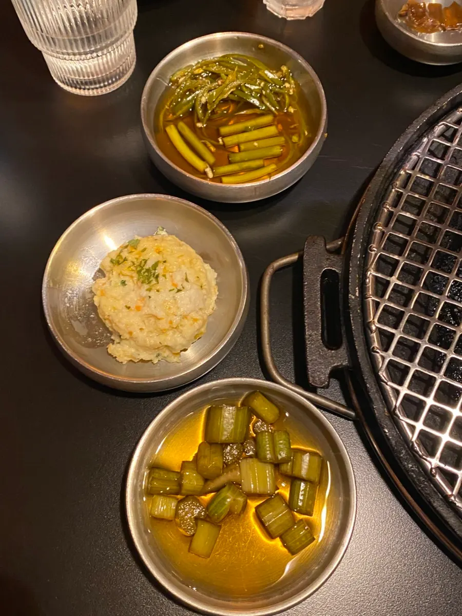 Side dishes including pickled gochujang chili and gat kimchi