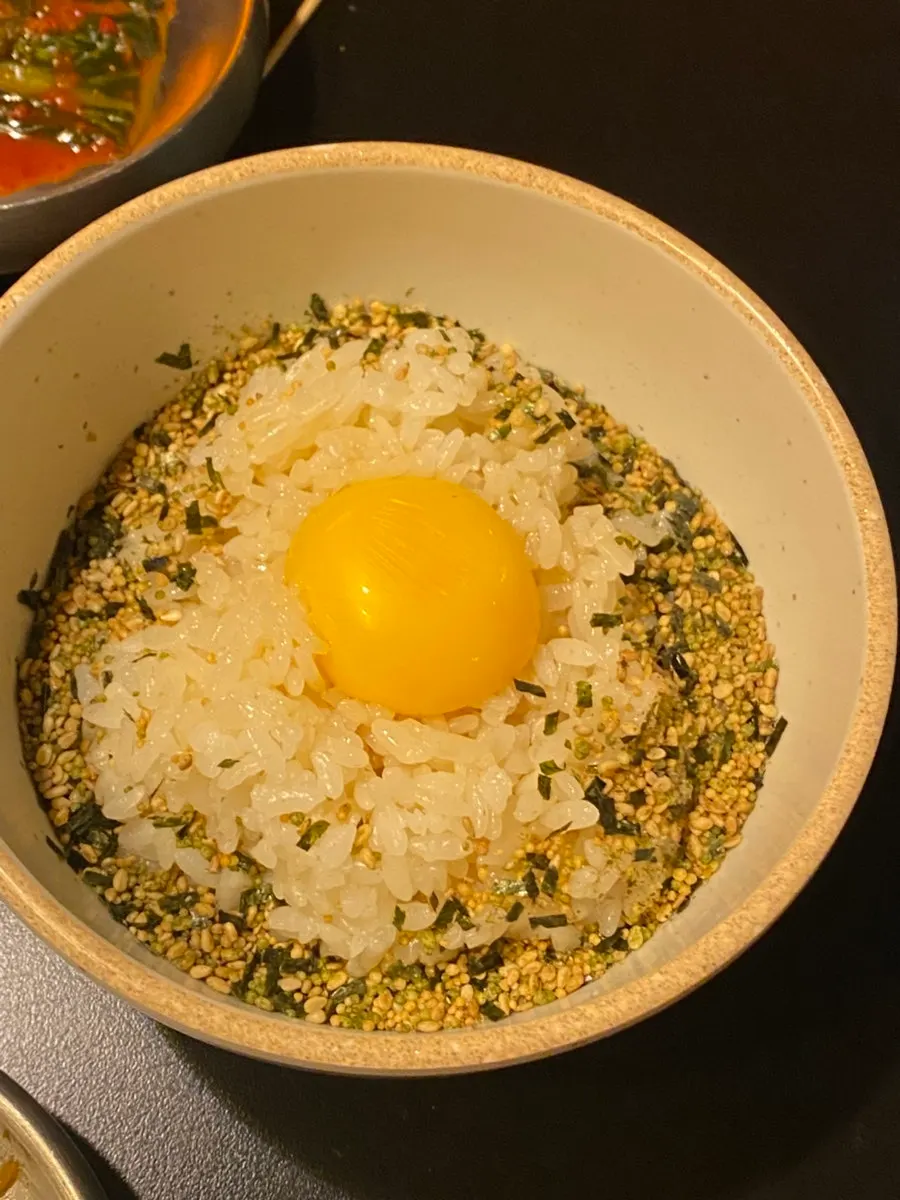 Soy sauce egg rice topped with yolk and furikake