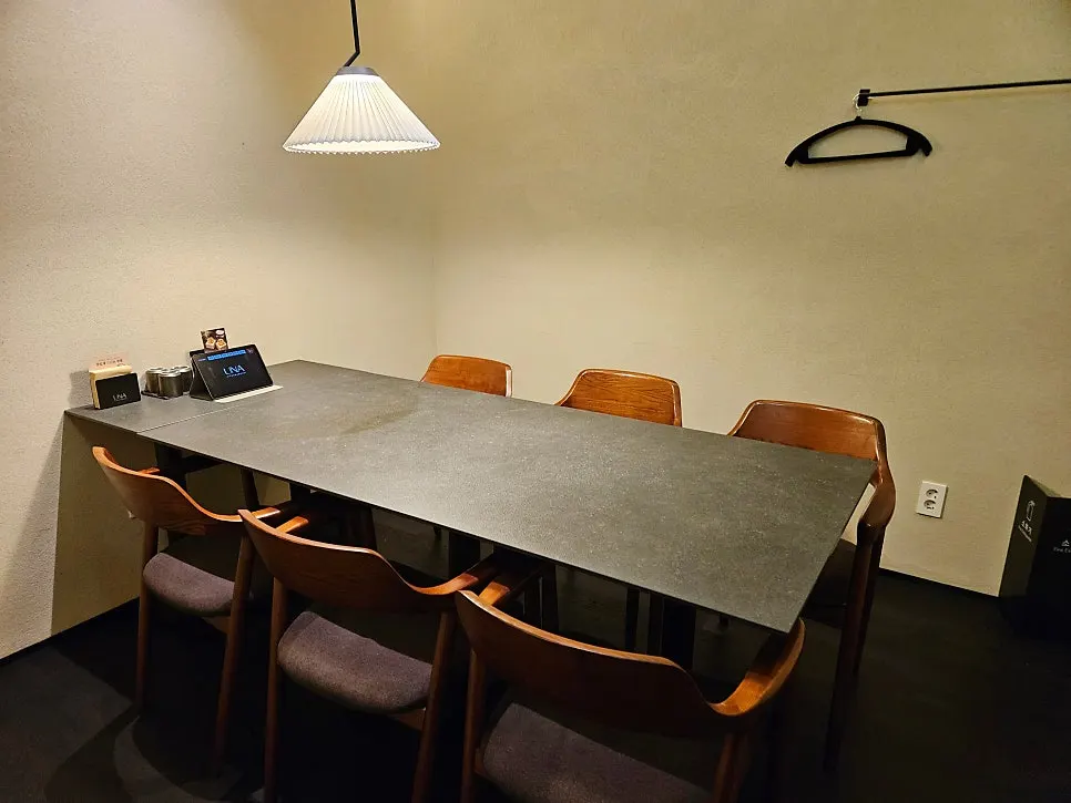 Sofa-style seating in the dark wood-tone interior of Una Magok