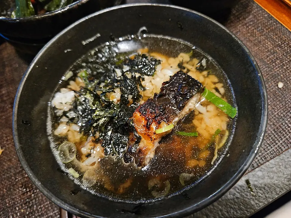 Preparing ochazuke by pouring broth over leftover rice and eel