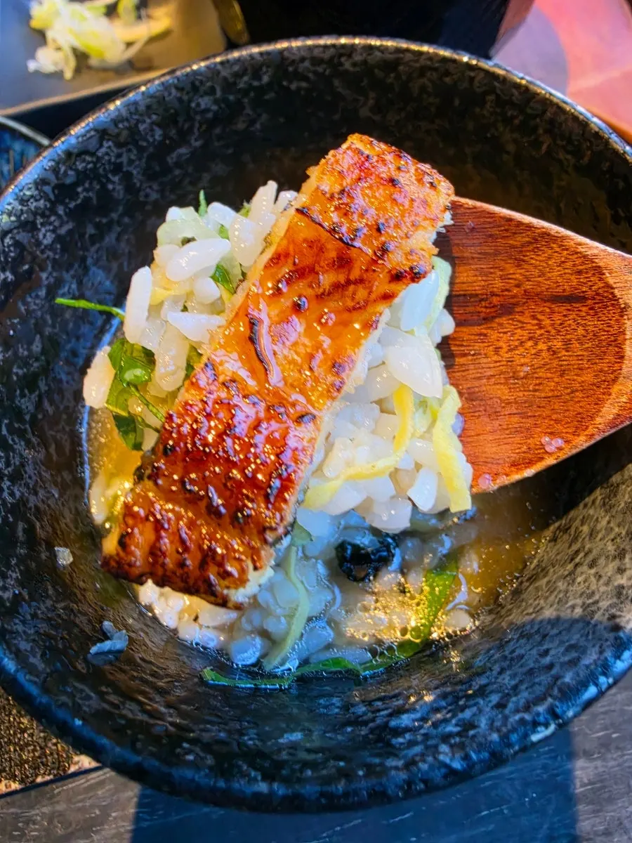 A bowl of hitsumabushi with garnish scooped over it