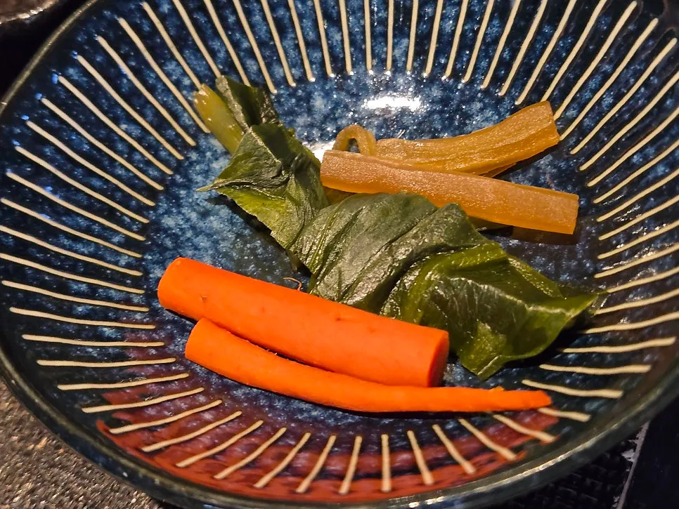 Plate of wasabi, seaweed flakes, scallion, and perilla leaf toppings