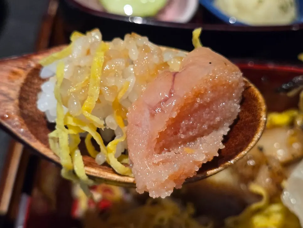 A bite of grilled eel wrapped in perilla leaf