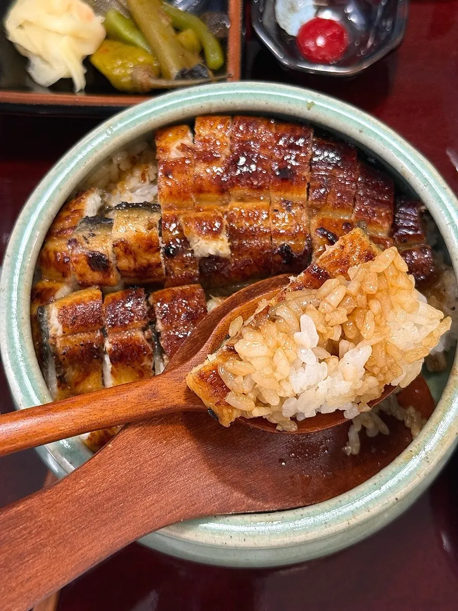A spoonful of eel glazed in sauce with rice