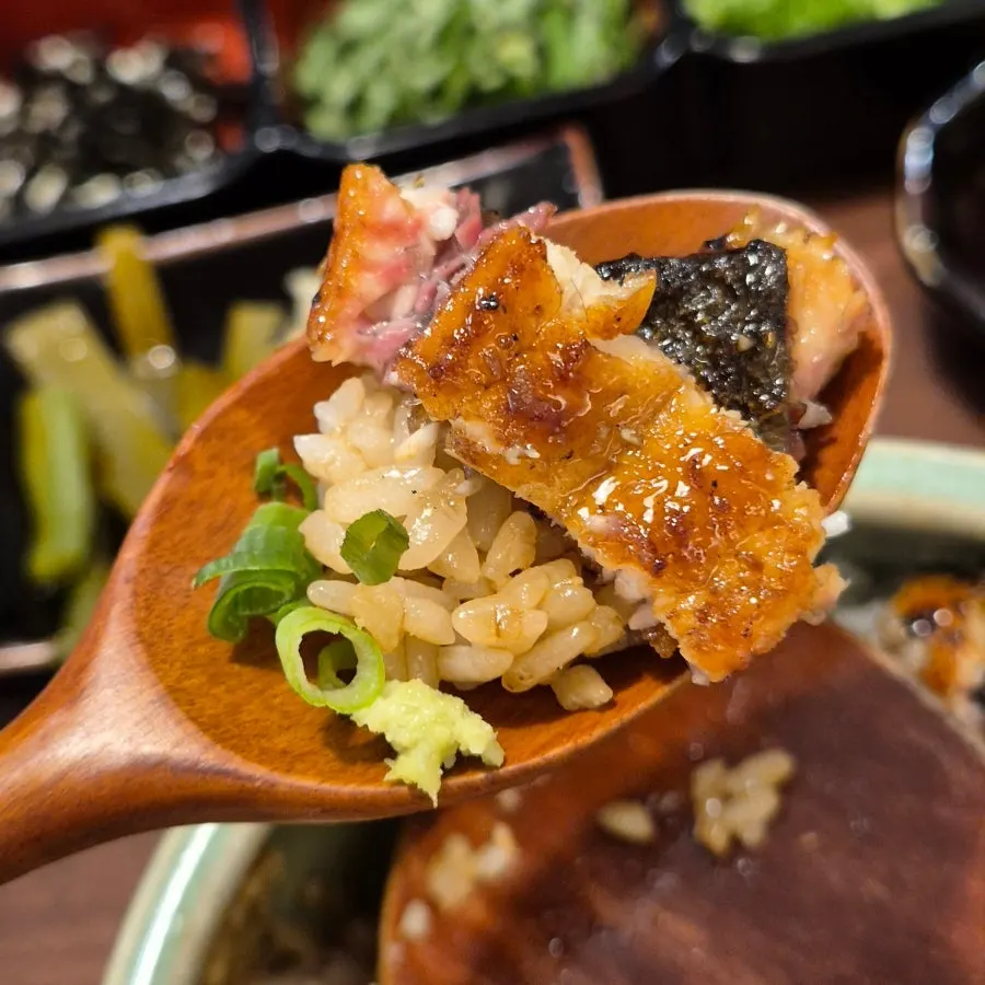 A spoonful of eel topped with wasabi and scallion
