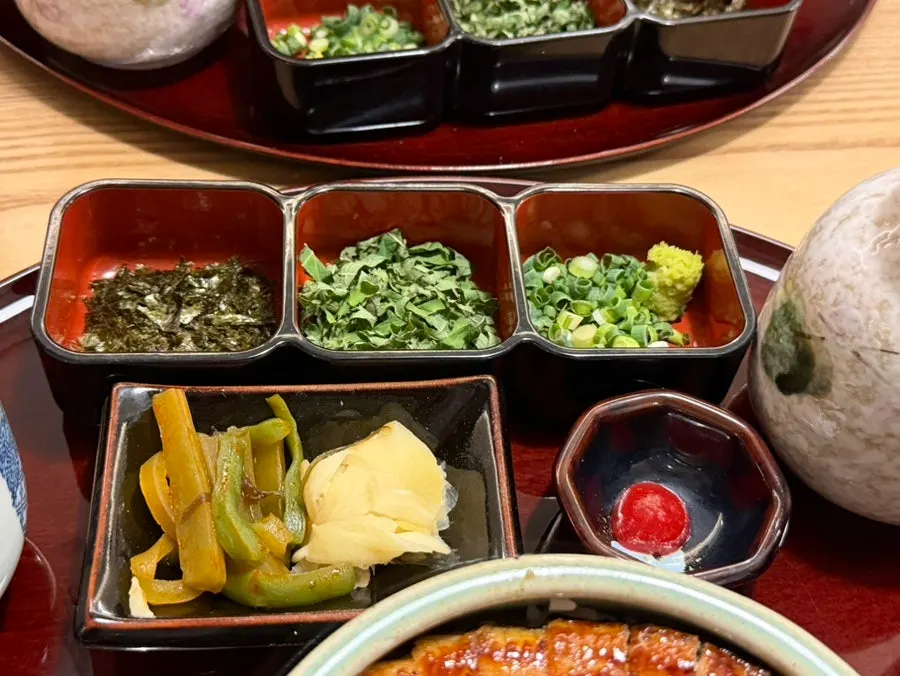 Pickles, plum sauce, seaweed, perilla leaf, scallion, and wasabi side dishes