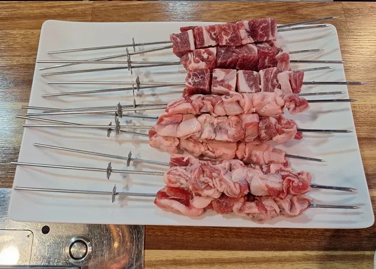 Lamb skewers rotating automatically over the grill