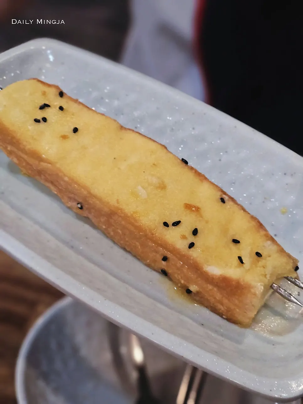 Bread skewer coated with condensed milk on metal rods