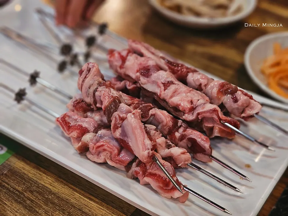 Eight thick raw lamb rib meat skewers
