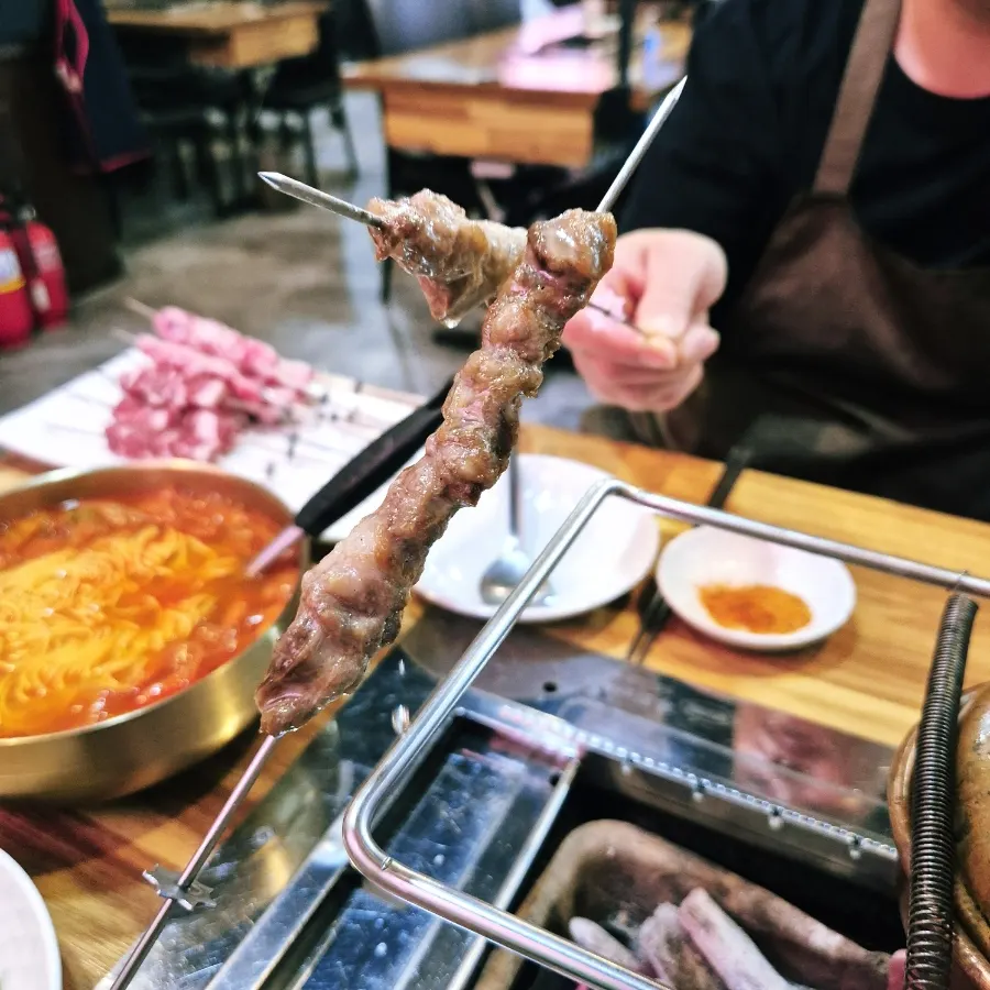 Picking up a fully cooked yang kkochi skewer
