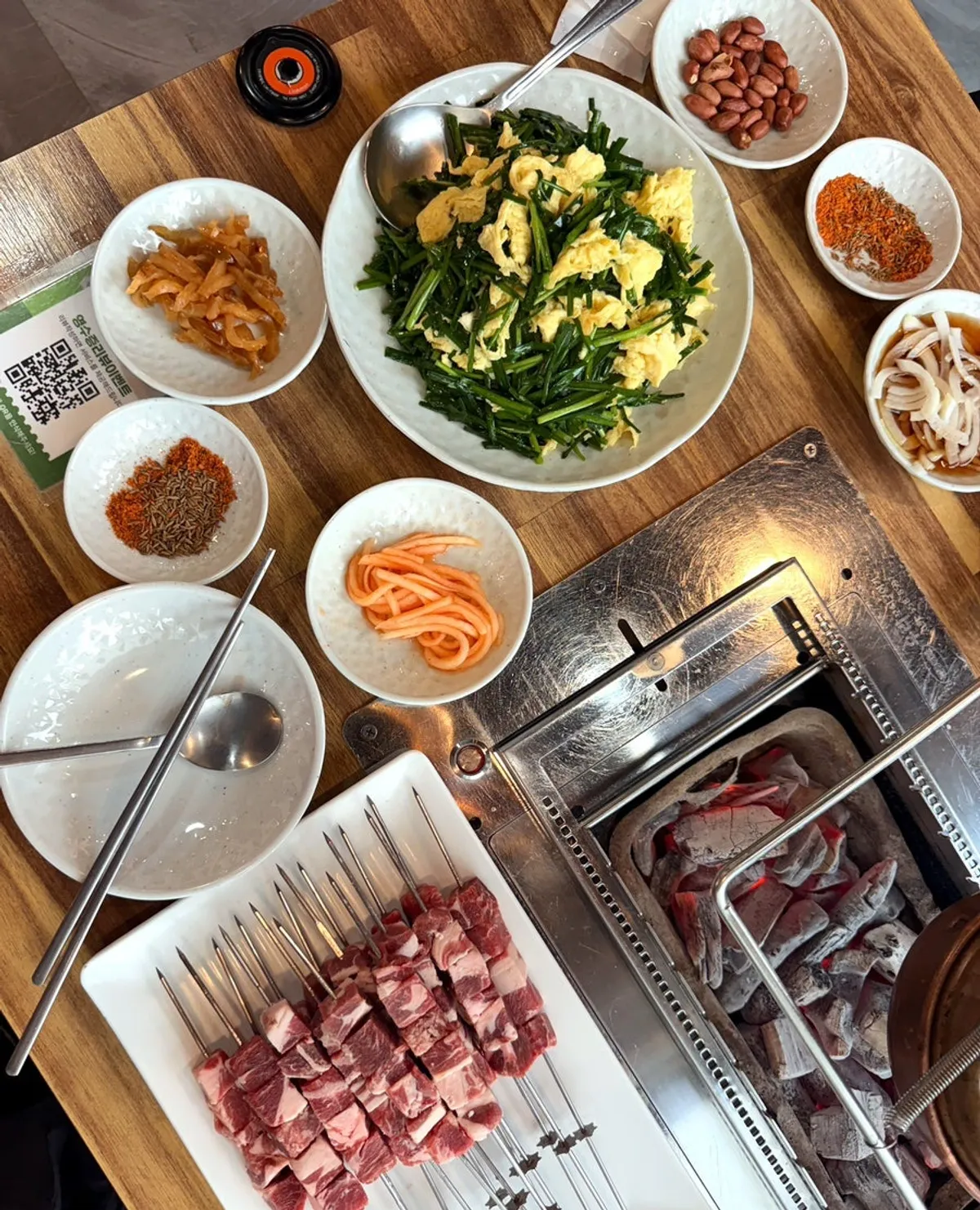 A full table set with lamb skewers and side dishes