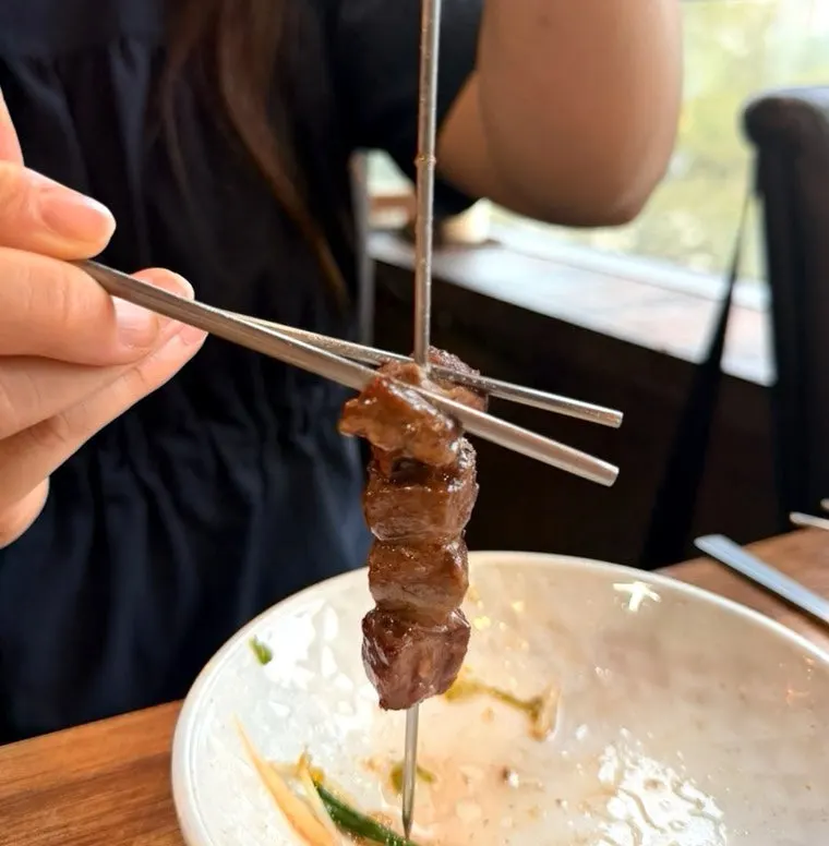 A piece of lamb skewer dipped in cumin salt