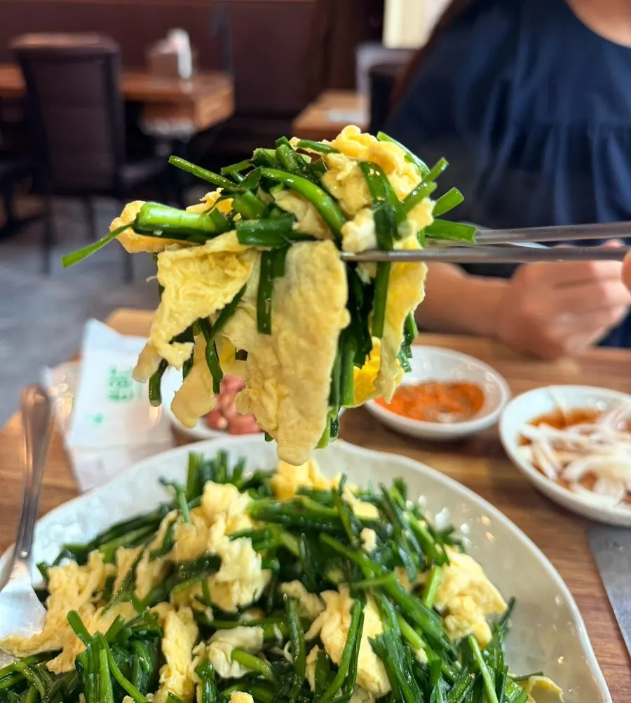 Chive egg stir-fry lifted up with chopsticks