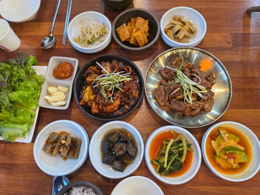 Table set with cheonggukjang, pork bulgogi, and stir-fried octopus