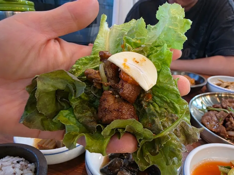 A lettuce wrap topped with pork bulgogi and garlic