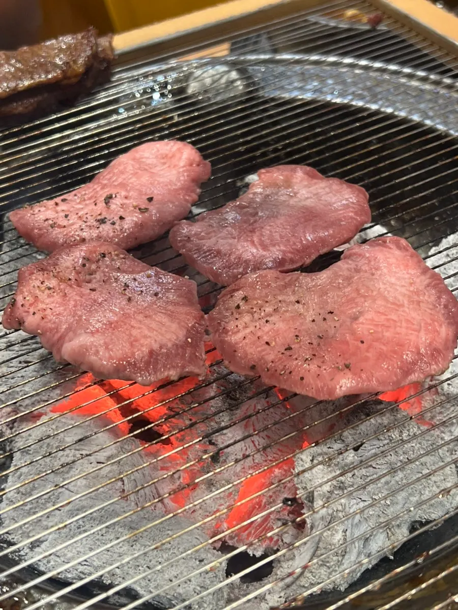 Beef tongue grilling over charcoal