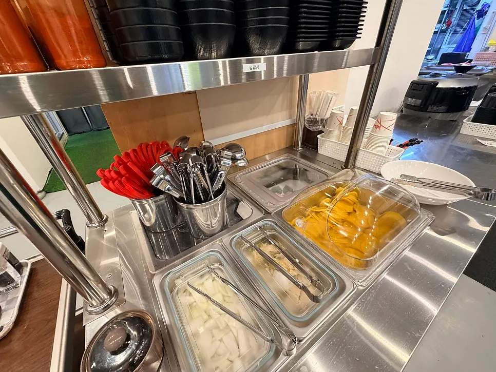 Self-serve bar with onion and baek-kimchi at Bongga Gyodong Banjeom