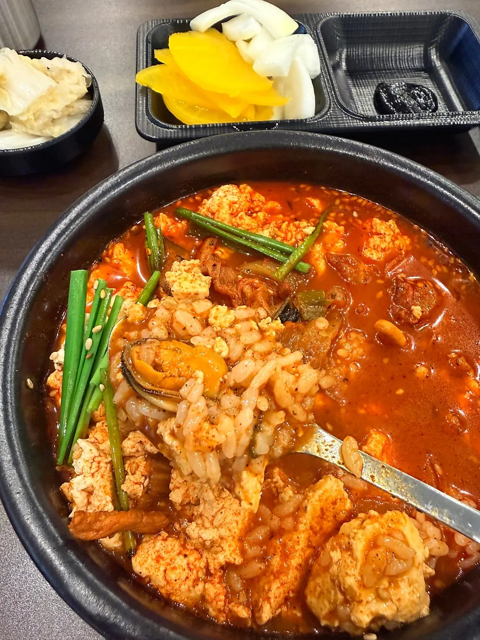 A spoonful of soft tofu dipped in the broth