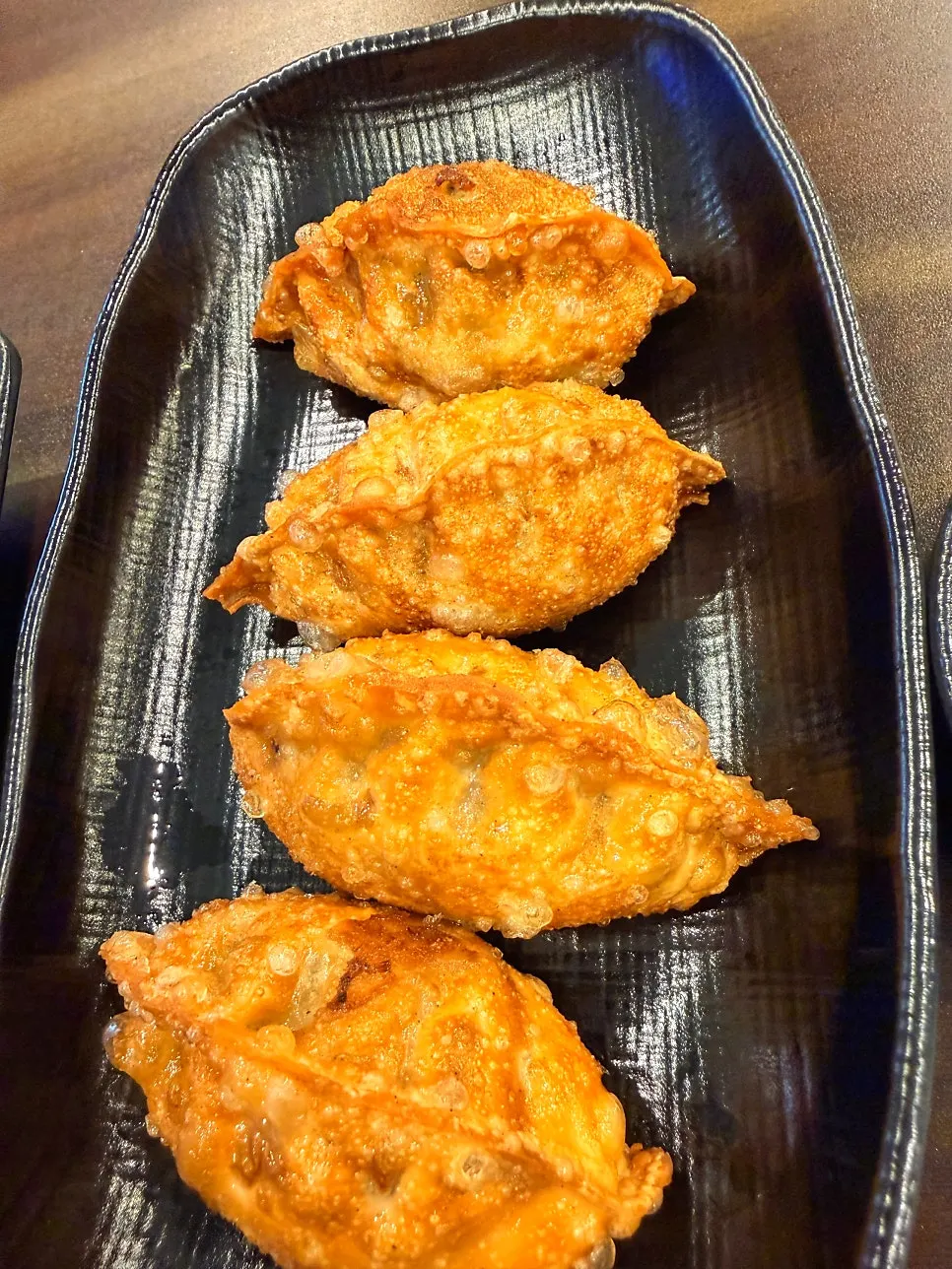 Four fried mandu on a plate