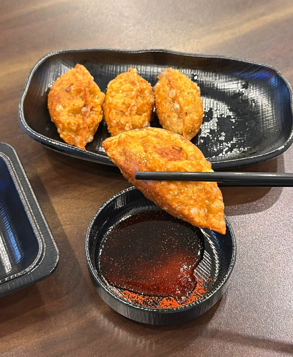 Short, plump fried mandu dipped in soy sauce and red pepper flake sauce