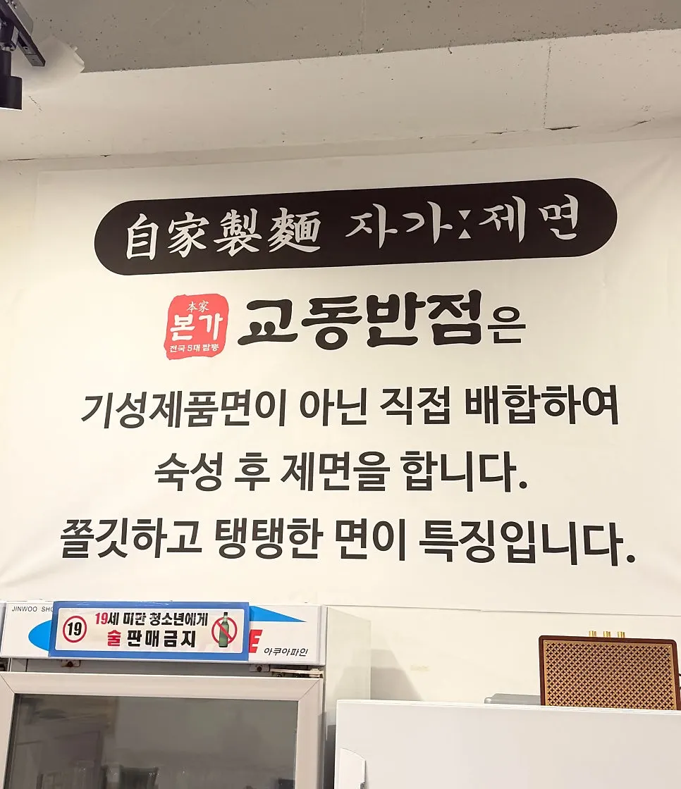 Interior of Bongga Gyodong Banjeom with a sign about in-house noodle making