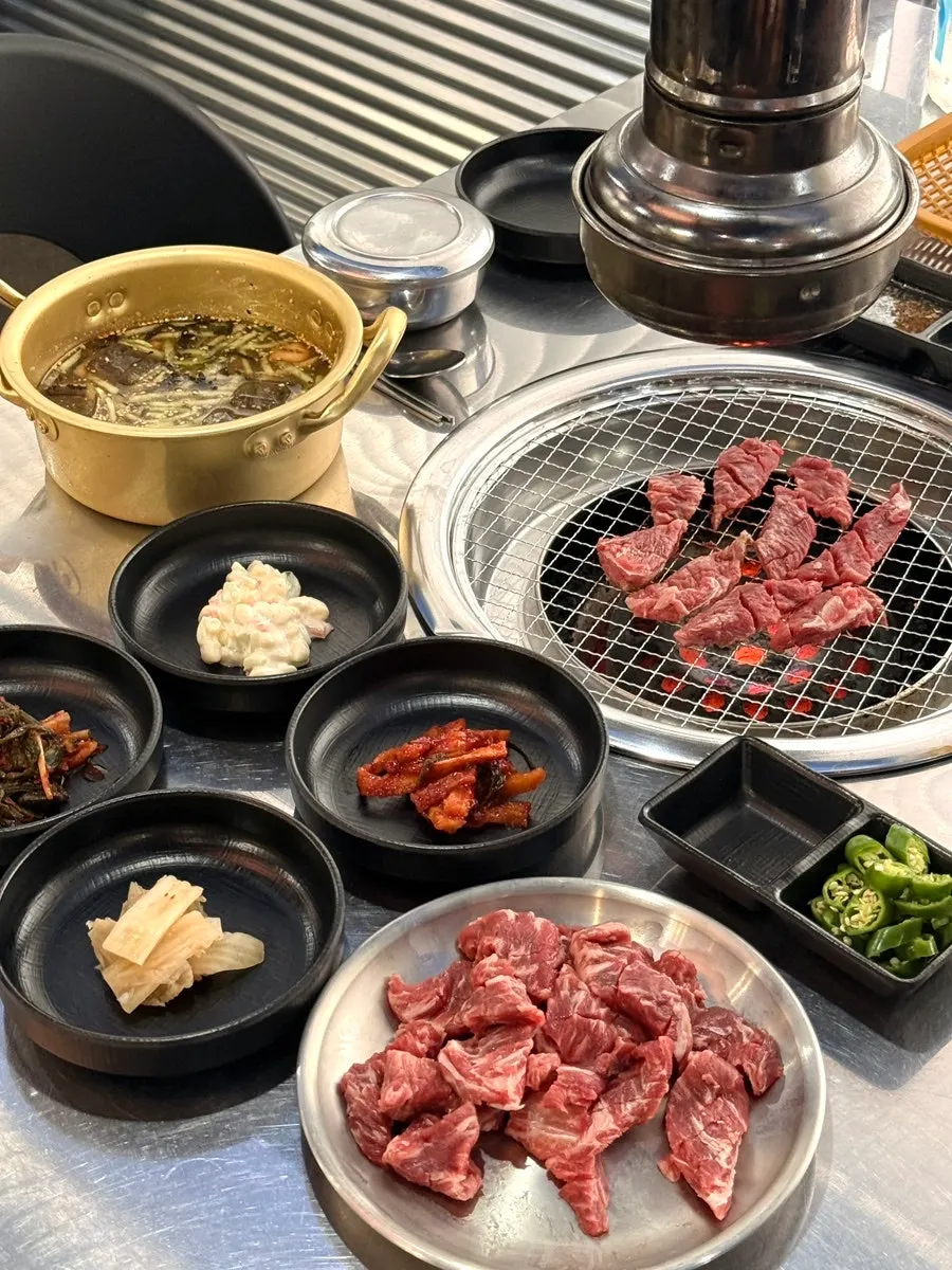 Short rib placed on the charcoal grill with the full table spread