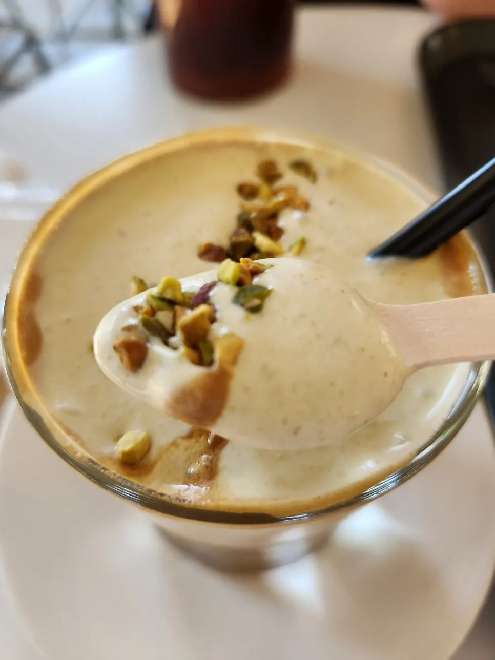 Pistachio cream latte served with a wooden spoon
