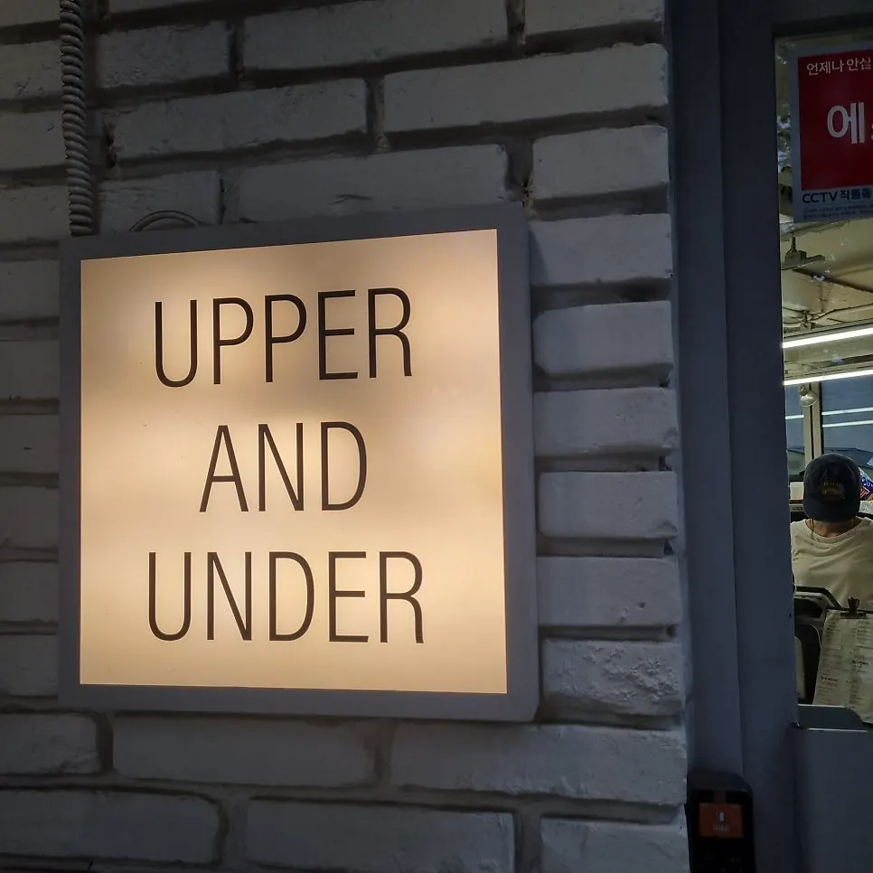 Exterior of the Upper and Under building softly lit at night