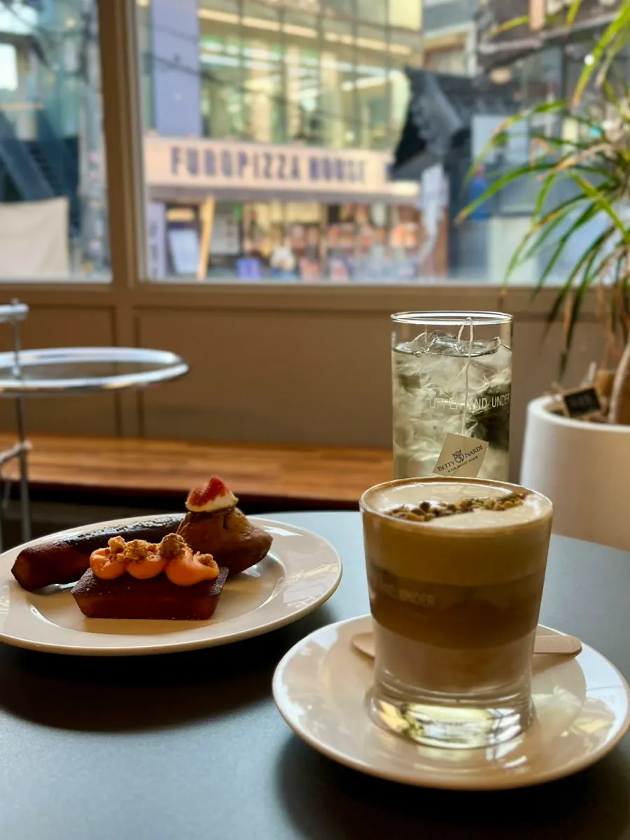 Drinks and desserts set on a window-side table