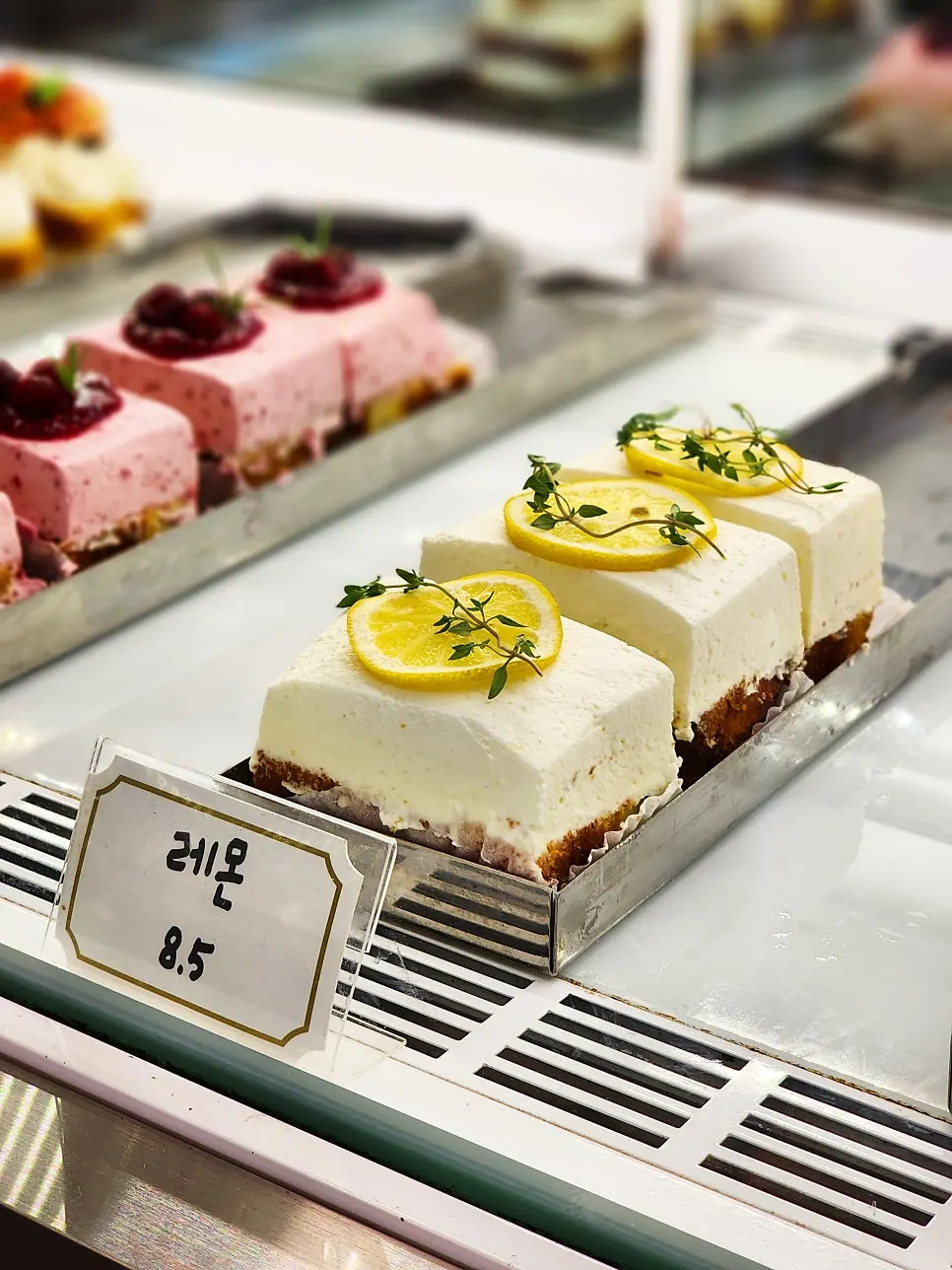 Display case showing lemon and raspberry cakes