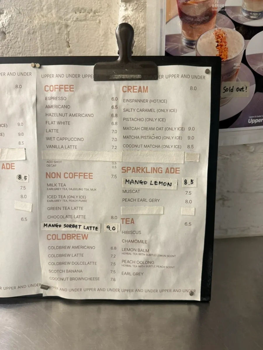 Menu board listing coffee, non-coffee and ade drinks