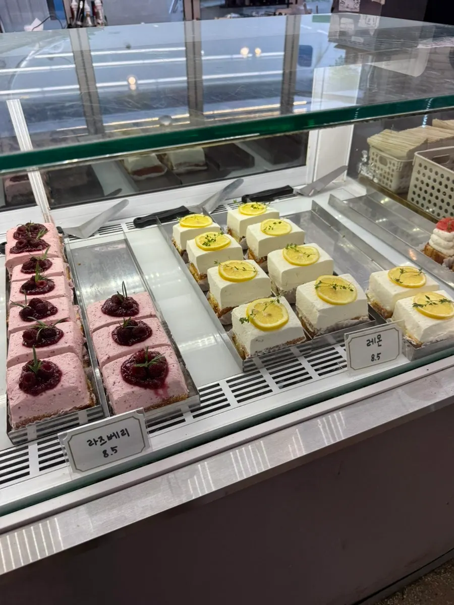 Display of fig, tiramisu, raspberry and other cakes