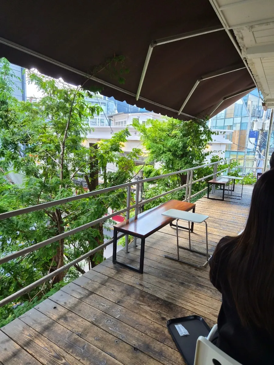 Outdoor terrace seating at Upper and Under surrounded by trees