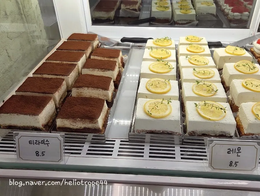Cake slices lined up in the refrigerated display case at Upper and Under